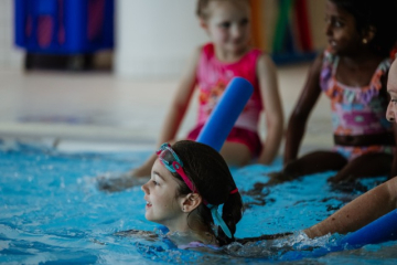 Mädchen m Nudel schwimmt los hinten Kids Beckenrand (ChristinaPoersch_214A207420250619)